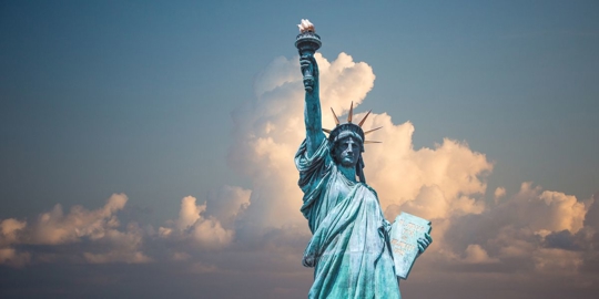 The Statue of Liberty with skies and clouds as the backdrop